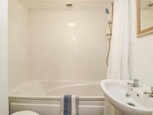 La salle de bains blanche est pourvue d'une baignoire et d'un lavabo. dans l'établissement Seashells, à Hornsea