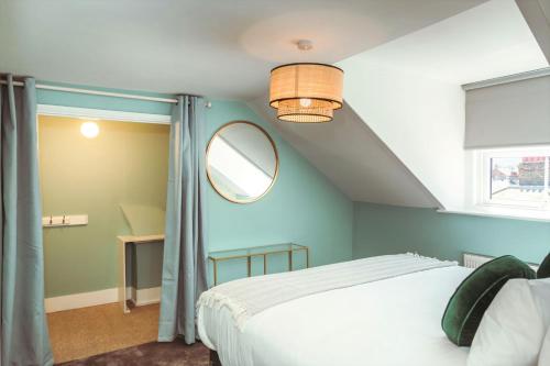 a bedroom with a white bed and a mirror at Central Breaks - split level, spacious getaway in Eastbourne