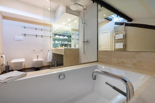 a bathroom with a tub and a sink and a mirror at Navona 49 Luxury Suites&Apartment in Rome