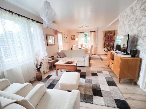 sala de estar con muebles blancos y alfombra a cuadros en Ruma ankanpoikanen, en Pori