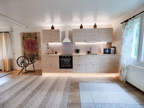 a large kitchen with white cabinets and a large window at Ruma ankanpoikanen in Pori