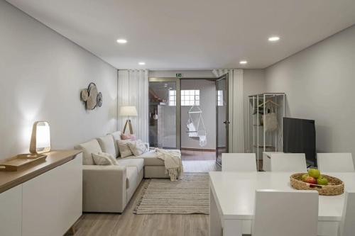 a white living room with a couch and a table at Casa das Raposinhas II in Funchal