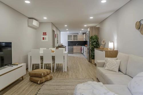 a living room with a white couch and a table at Casa das Raposinhas II in Funchal