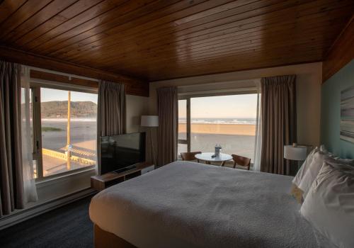 a bedroom with a large bed and a large window at The Ocean Front at Seaside in Seaside