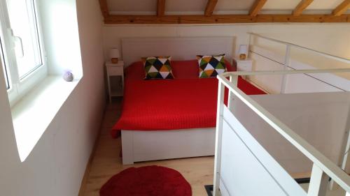 a small bedroom with a red bed and stairs at Holiday Home Bobovisca in Ložišće