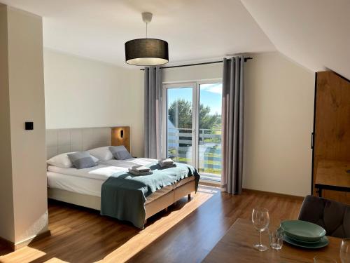 a bedroom with a bed and a large window at Apartamenty MarSyl in Jastrzębia Góra
