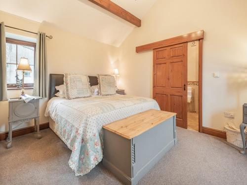 1 dormitorio con 1 cama y puerta de madera en Beckside en Gilcrux