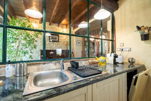 une cuisine avec un évier et une grande fenêtre dans l'établissement La Maison de Yûka, à Plieux