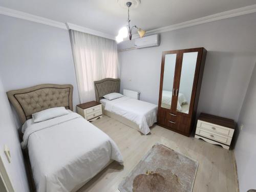 a bedroom with two beds and a mirror at Deniz manzaralı klimalı daire in Bostancı