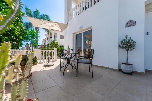 a patio with a table and chairs and an umbrella at Lemon Tree Villa in Paralimni