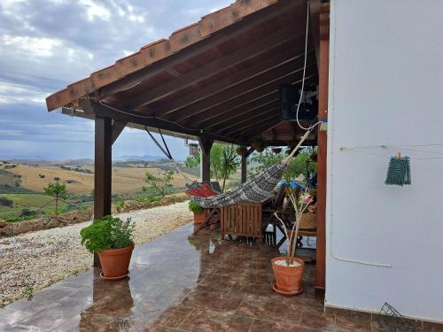 a porch with a hammock under a roof at Salvador in Málaga