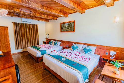 a hotel room with two beds and a table at Palm Bay Resort Phu Quoc in Phú Quốc