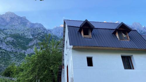 a house with windows on the side of it with mountains at Guesthouse Rexhepi in Kolgecaj