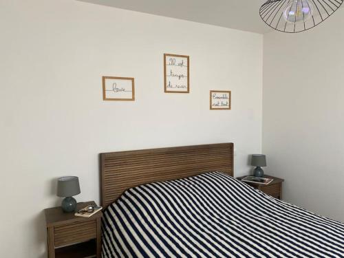 a bedroom with a bed and three clocks on the wall at Appt confort avec terrasse au calme à Fouras! in Fouras