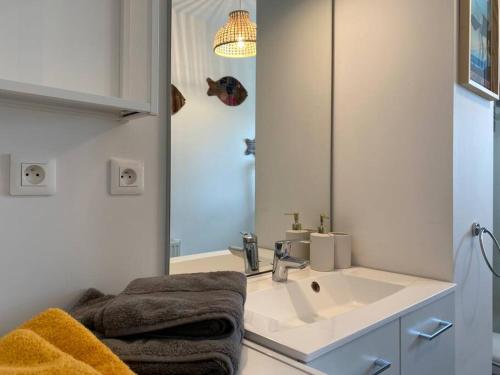 a bathroom with a sink and a mirror at Appt confort avec terrasse au calme à Fouras! in Fouras