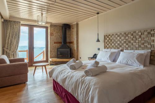 a bedroom with a large white bed with a fireplace at 5 Ραχες/5 Raches in Arachova