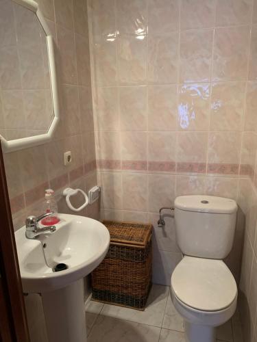 een badkamer met een wit toilet en een wastafel bij piso en la playa in Noja