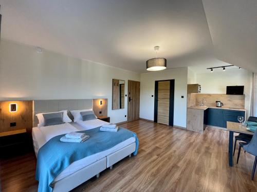 a bedroom with a large bed and a kitchen at Apartamenty MarSyl in Jastrzębia Góra