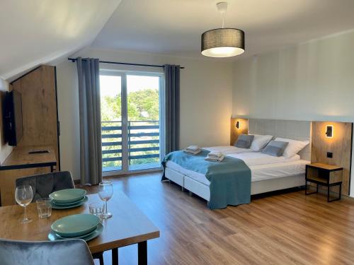 a bedroom with a bed and a table and a dining room at Apartamenty MarSyl in Jastrzębia Góra