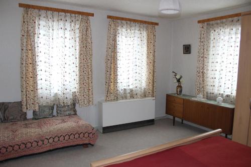 a bedroom with a bed and a dresser and windows at Sleep in Lerbach in Osterode