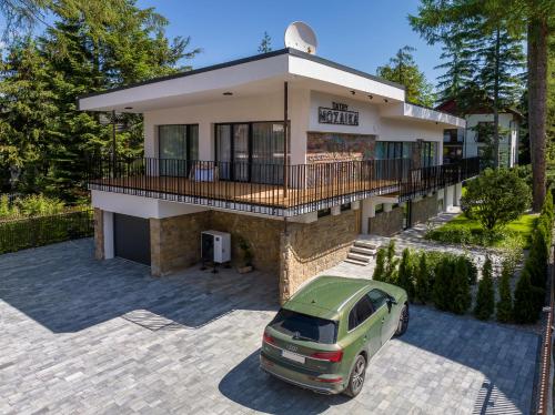 a car parked in front of a house at Tatry Mozaika Willa PREMIUM & SPA - Sauna, Jacuzzi, Flipper by RentiloPL in Zakopane
