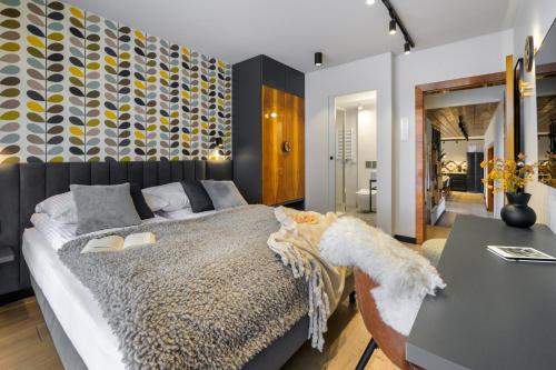 a bedroom with a large bed and a desk at Tatry Mozaika Willa PREMIUM & SPA - Sauna, Jacuzzi, Flipper by RentiloPL in Zakopane