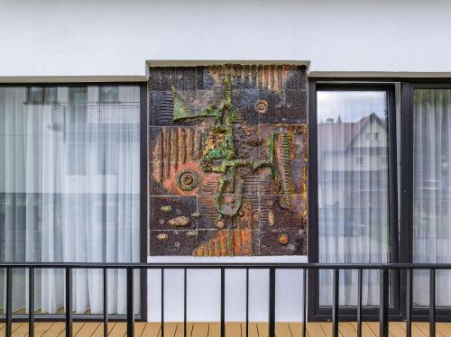 a mosaic on a wall next to a window at Tatry Mozaika Willa PREMIUM & SPA - Sauna, Jacuzzi, Flipper by RentiloPL in Zakopane