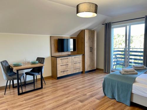 a bedroom with a bed and a desk and a table at Apartamenty MarSyl in Jastrzębia Góra