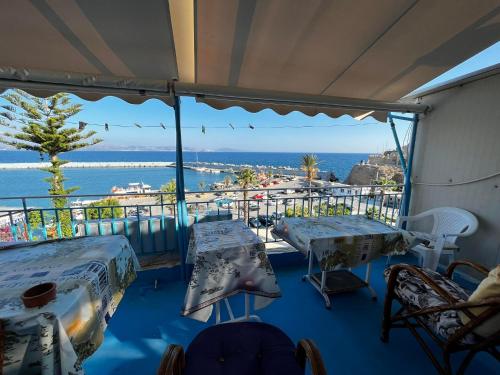 a room with tables and a view of the ocean at Selena Rooms in Agia Galini