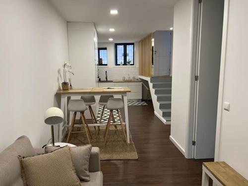 sala de estar y cocina con sofá y mesa en Porto Apartamento relaxante na cidade en Oporto