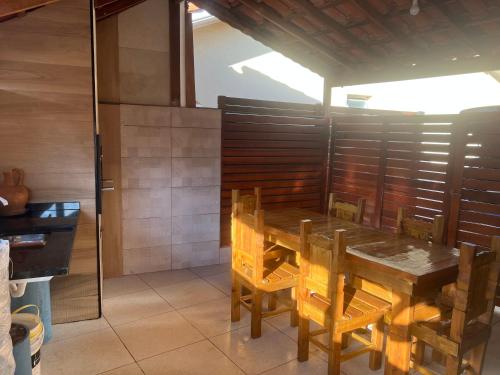 a dining room with a wooden table and chairs at Chalé em Resort in Mairinque