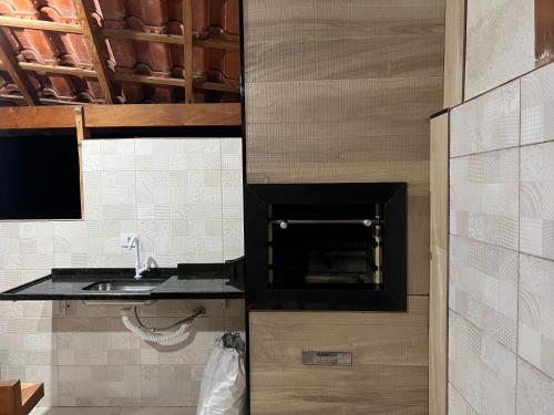 a kitchen with a sink and a counter top at Chalé em Resort in Mairinque