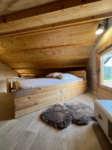 a bedroom with a bed in a log cabin at Tiny-House Chalet Al måjhinete in Lodève