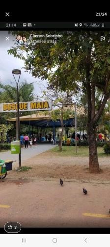 ein Schild für ein Geschäft in einem Park mit Vögeln auf dem Boden in der Unterkunft kitnet casa completa in Guarulhos