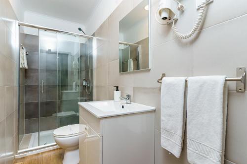 a bathroom with a toilet sink and a shower at Mar- Milfontes Rentals in Vila Nova de Milfontes