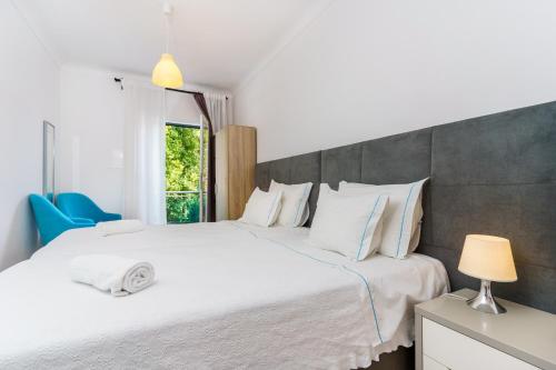a bedroom with two beds and a window at Mar- Milfontes Rentals in Vila Nova de Milfontes