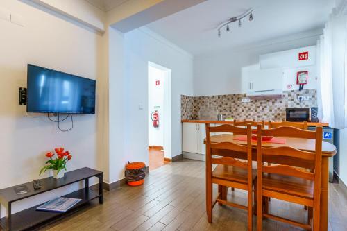 a kitchen and a dining room with a table and a television at Mar- Milfontes Rentals in Vila Nova de Milfontes