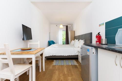 um quarto com uma cama e uma cozinha com uma mesa em Mar- Milfontes Rentals em Vila Nova de Milfontes