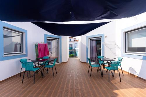 a dining room with chairs and tables and a blue tent at Mar- Milfontes Rentals in Vila Nova de Milfontes