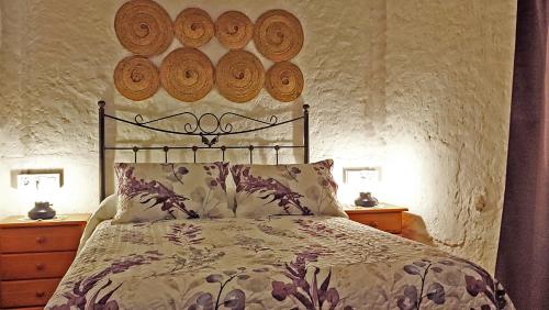 Schlafzimmer mit einem Bett mit Holzplatten an der Wand in der Unterkunft Cortijo AguaChá in Bayacas