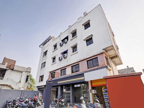 een wit gebouw met motoren ervoor geparkeerd bij OYO Flagship 84221 Marvel Inn in Nagpur