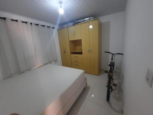 a bedroom with a bed and a bike in it at Chalé em Resort in Mairinque