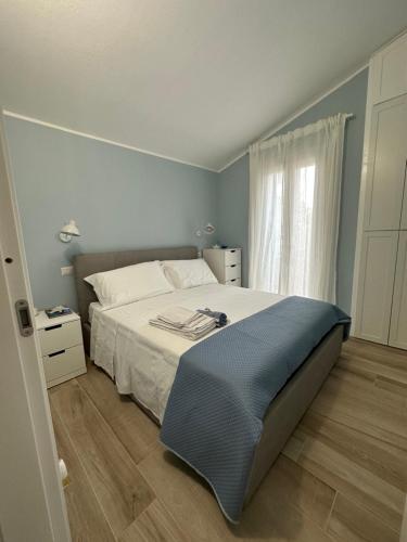 sypialnia z białym łóżkiem i oknem w obiekcie My Happy Place w mieście Calasetta
