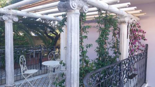 a pergola with a table and chairs on a balcony at B&B Domus Aurea 20 in San Giovanni Teatino