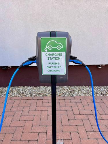 a sign for a charging station on a brick sidewalk at Boutique Hotel & Event Center in Budapest