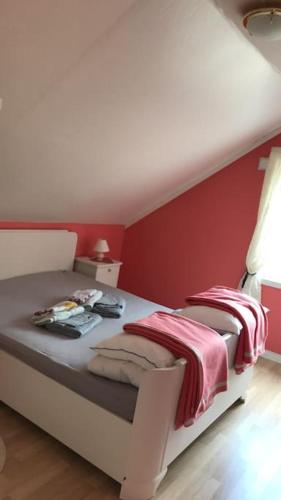 a bedroom with a bed with red walls at Sommerhus, Edvinstua. in Pettvik