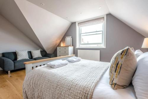 ein Schlafzimmer mit einem Bett, einem Sofa und einem Fenster in der Unterkunft Lyndhurst in Aldeburgh