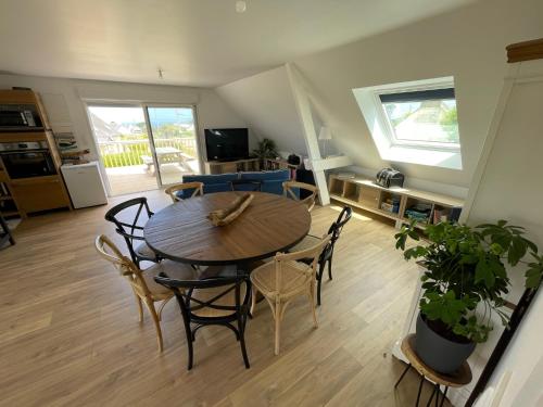 un salon avec une table et des chaises en bois dans l'établissement Logement pour 6 personnes 800 m des plages, à Saint-Pabu