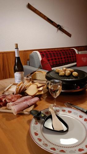 - une table avec une assiette de nourriture et une bouteille de vin dans l'établissement Appartement pied des pistes - Samoëns 1600, à Samoëns
