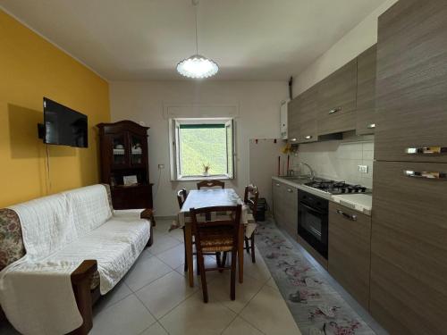 a living room with a couch and a table in a kitchen at Casa San Giacomo in Poggio Bustone